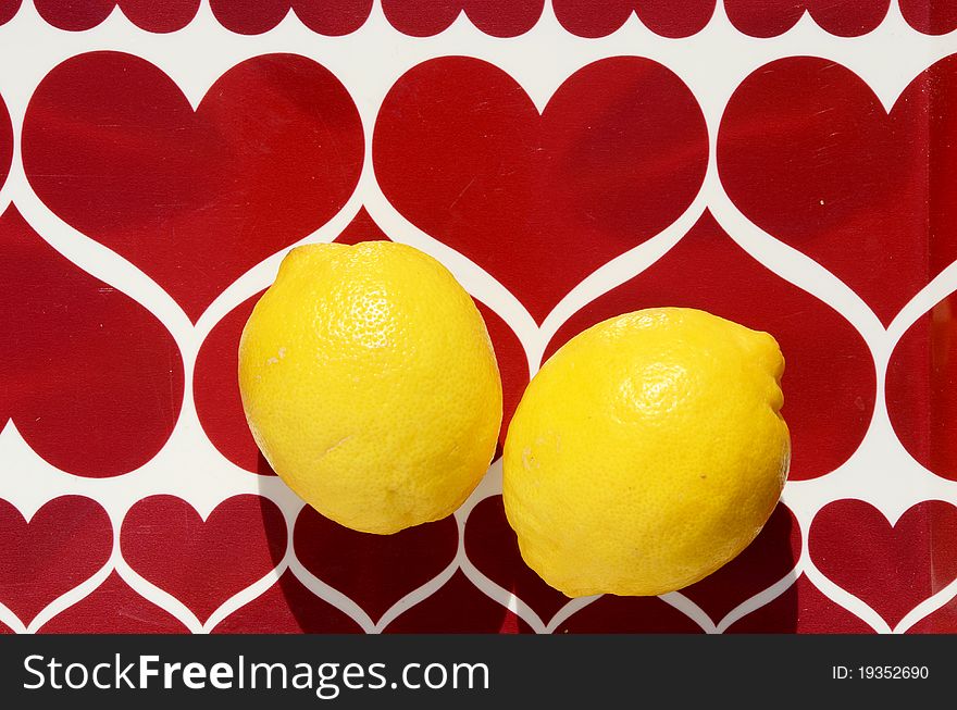 Two yellow lemons on hearts background