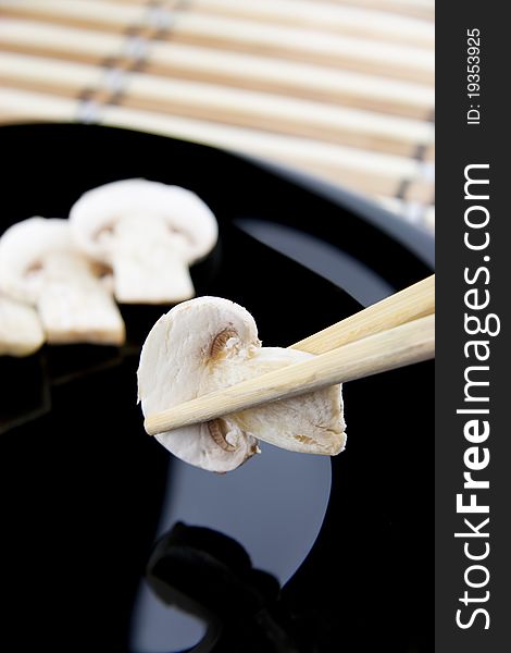 Holding Mushrooms with chopsitcks above a plate