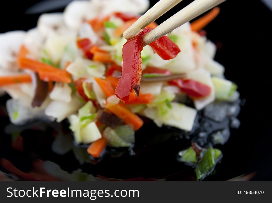 Holding paprika with chopsticks above the plate