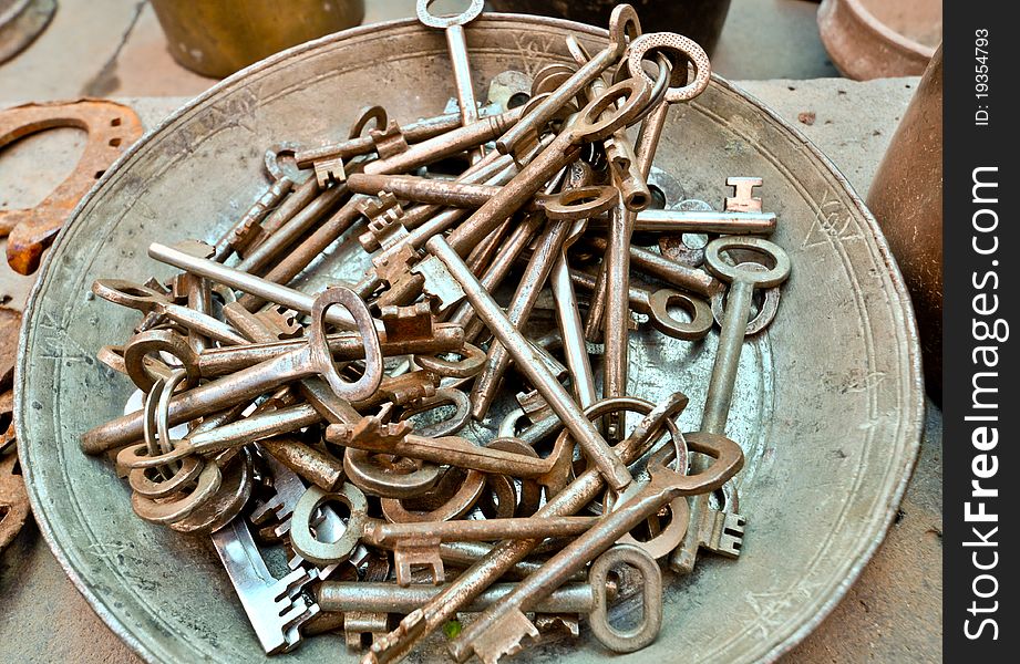A lot of old brass key on an old plate