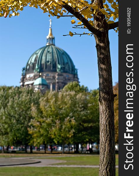 The Berlin cathedral behind green trees in the park. The Berlin cathedral behind green trees in the park