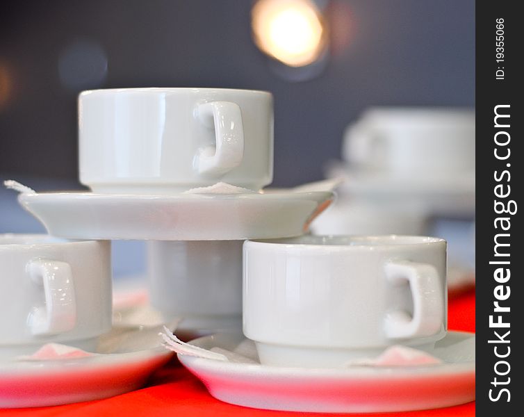 Three white porcelain tea cups and saucers and napkins