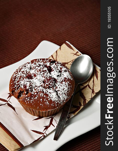 Chocolate muffin with cherries on ceramic plate. Chocolate muffin with cherries on ceramic plate