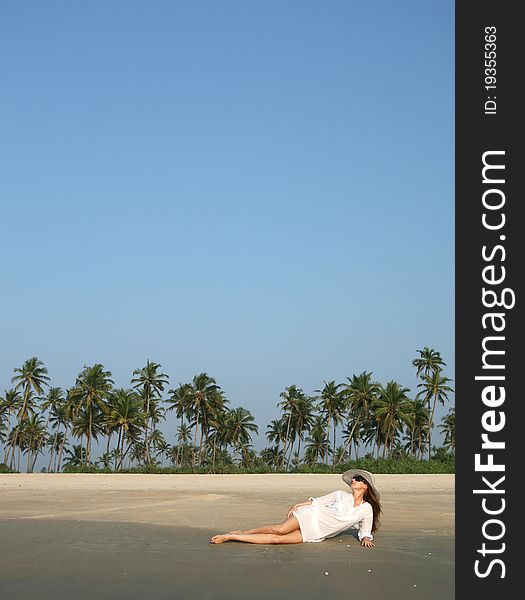 Woman in white hat lying on the beach in tropical country. Woman in white hat lying on the beach in tropical country