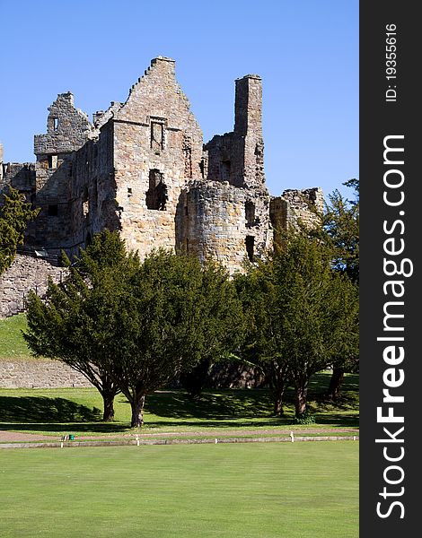 Dirleton Castle, East Lothian, Scotland with a saltire flag visible from a tower. Dirleton was founded as a medieval fortress by the de Vaux family around 1240.