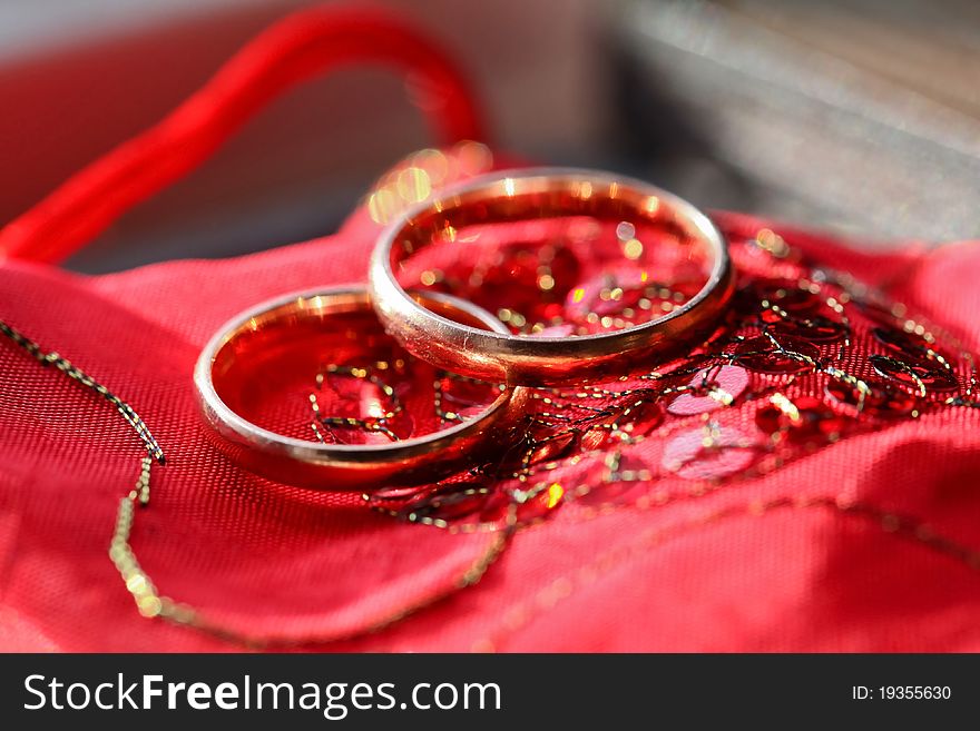 Wedding golden rings on the red silk material background. Wedding golden rings on the red silk material background