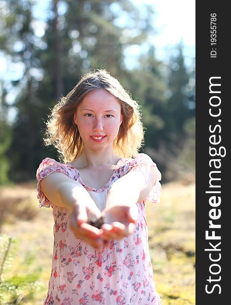 Sweet sexy woman in beautiful dress is standing in a sunshine on a golden field near the forest. Sweet sexy woman in beautiful dress is standing in a sunshine on a golden field near the forest