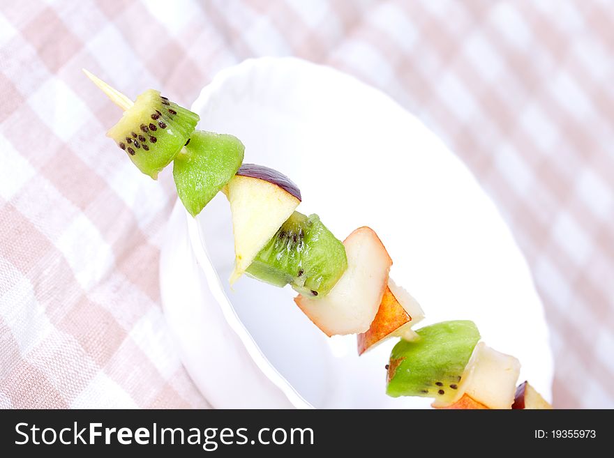 Fruit shashlik on white plate, closeup