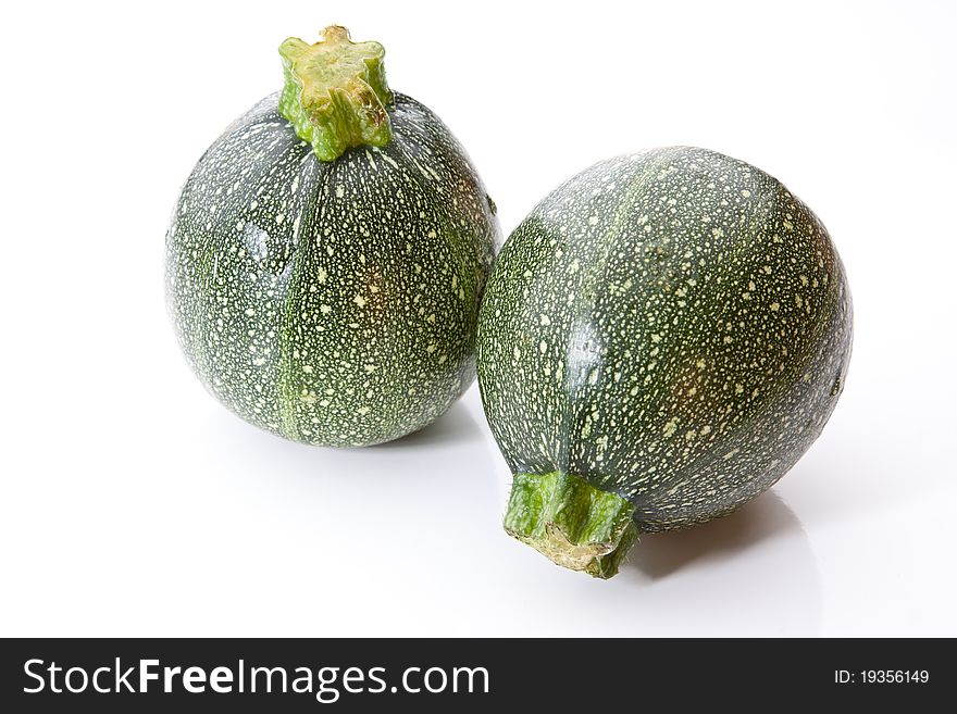 A pair of round courgettes isolated against a white background