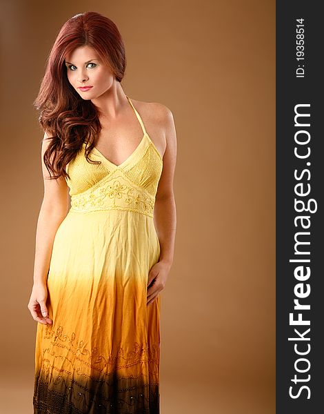 Model poses in studio wearing a pretty yellow dress. Model poses in studio wearing a pretty yellow dress.