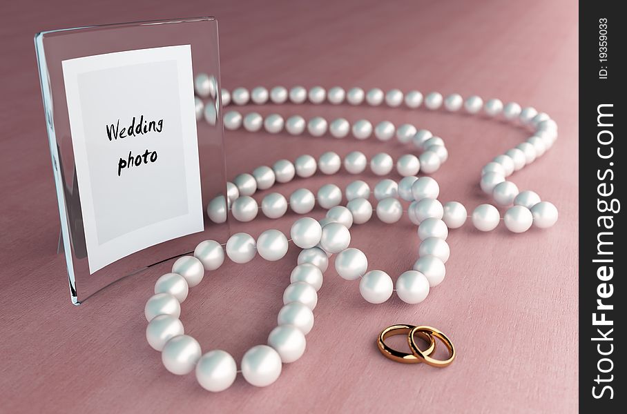 Glass frame on wood table with pearl beads and two rings. Glass frame on wood table with pearl beads and two rings