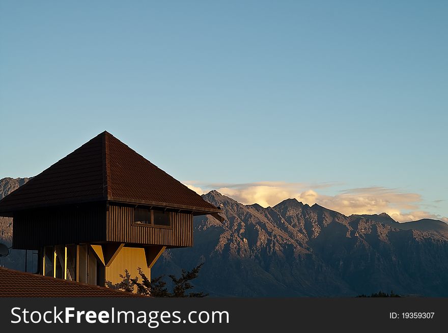 Wooden House On Rooftop With Mountain In The Backg