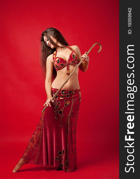 Young woman dance with cane in red arabic costume