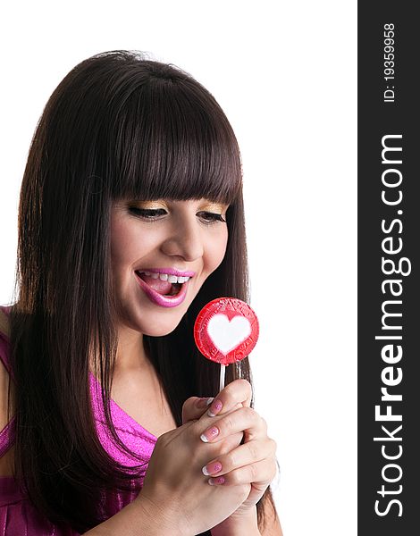 Young brunette woman look at heart lollipop