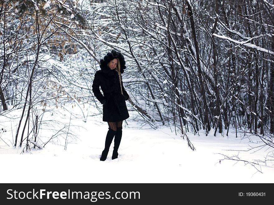 Nice young sweet girl is making a pose in a winter forest. Nice young sweet girl is making a pose in a winter forest
