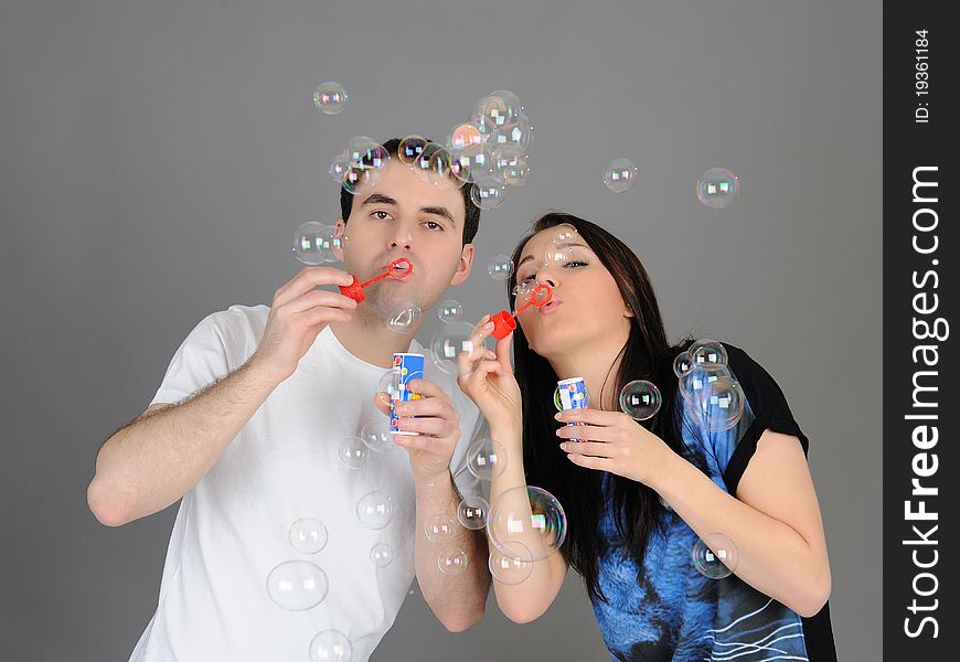 Pretty couple in love blowing bubbles and having fun