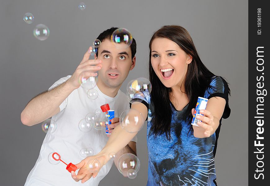 Pretty couple in love blowing bubbles and having fun