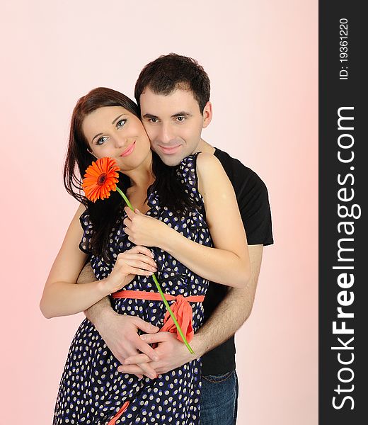 Lovely romantic man giving flower to a woman. pink background