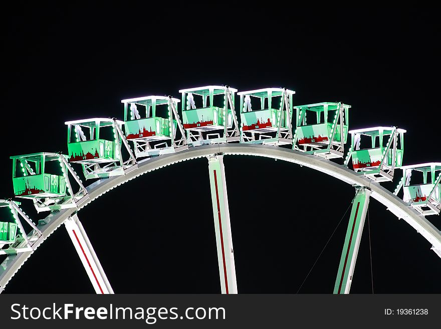 A big colorful ferris wheel at night.