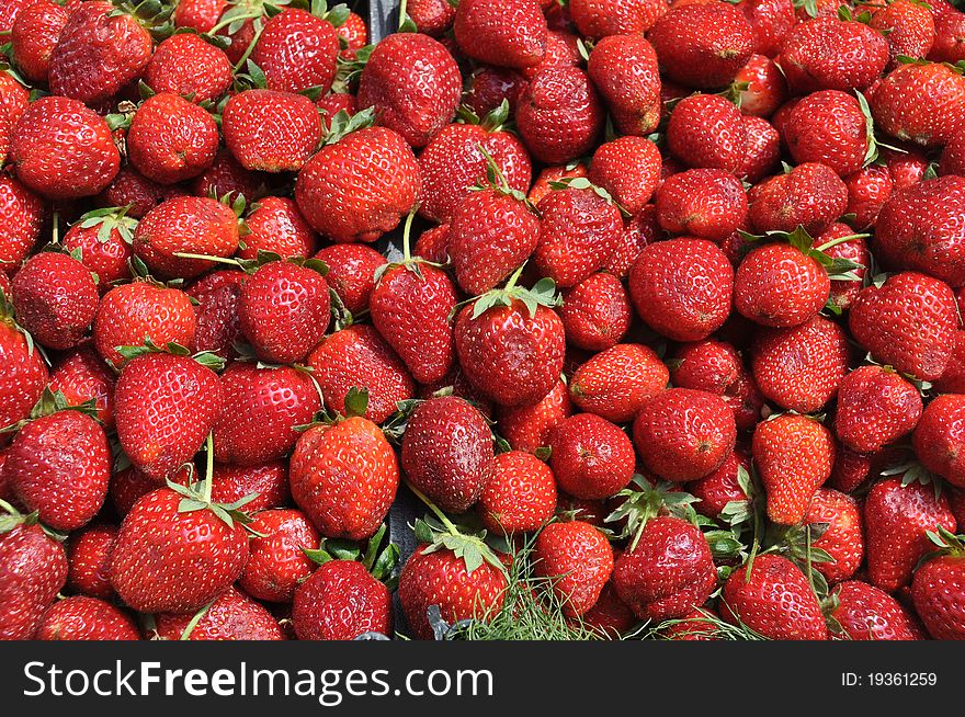 Fragrant, fleshy, juicy, red strawberries with seed-studded fleshy part and green leafy cap. Fragrant, fleshy, juicy, red strawberries with seed-studded fleshy part and green leafy cap.