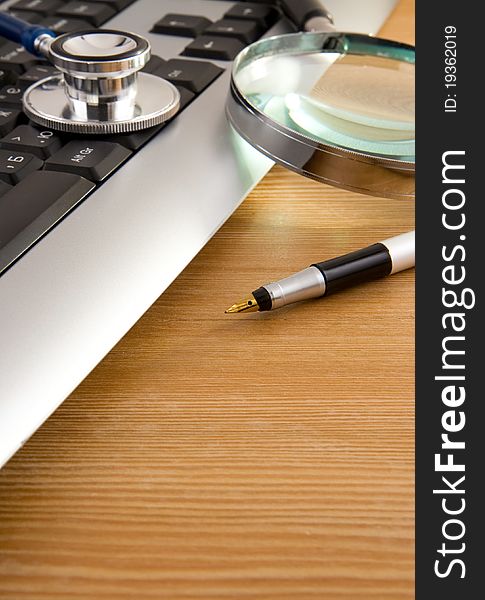 Stethoscope And Keyboard With Pen On Wood Texture