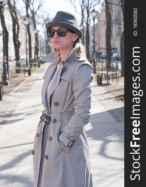 Beautiful young woman in a raincoat on the street