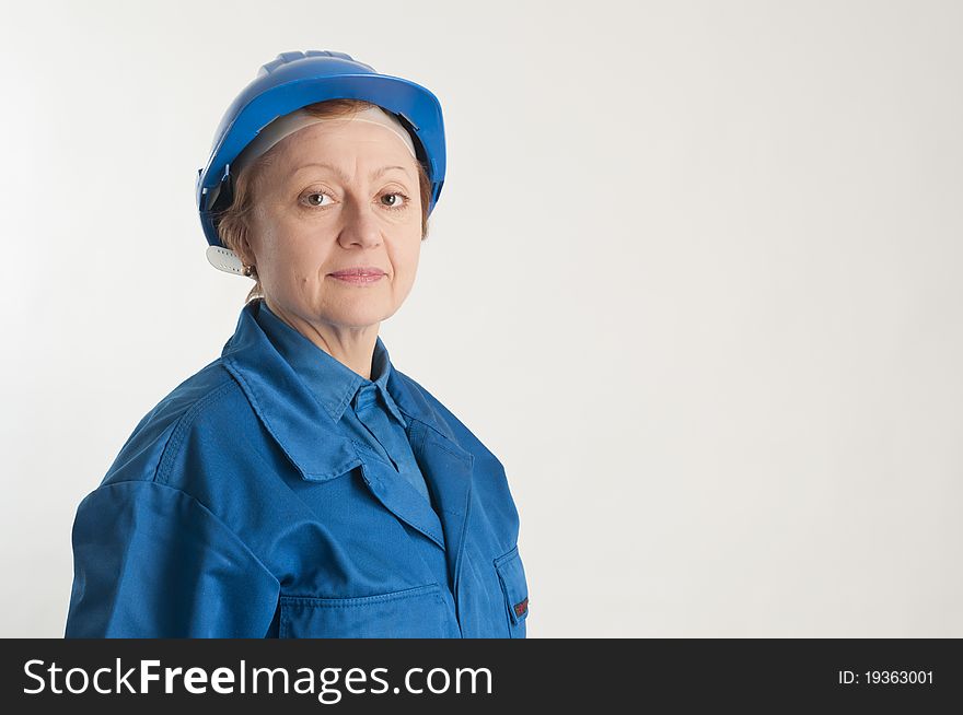 Adult engineer woman with a blue helmet on the head