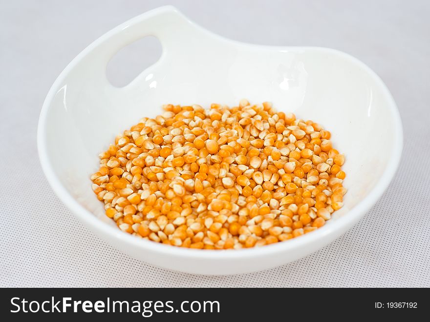 Pile Of Popcorn Seeds Isolated On White Bowl