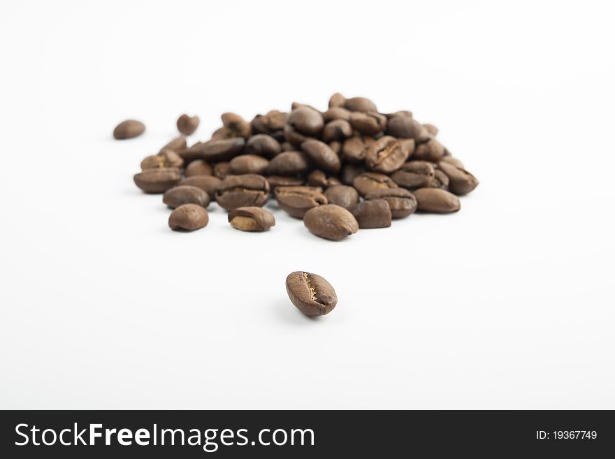 Coffee beans spilled on a white background