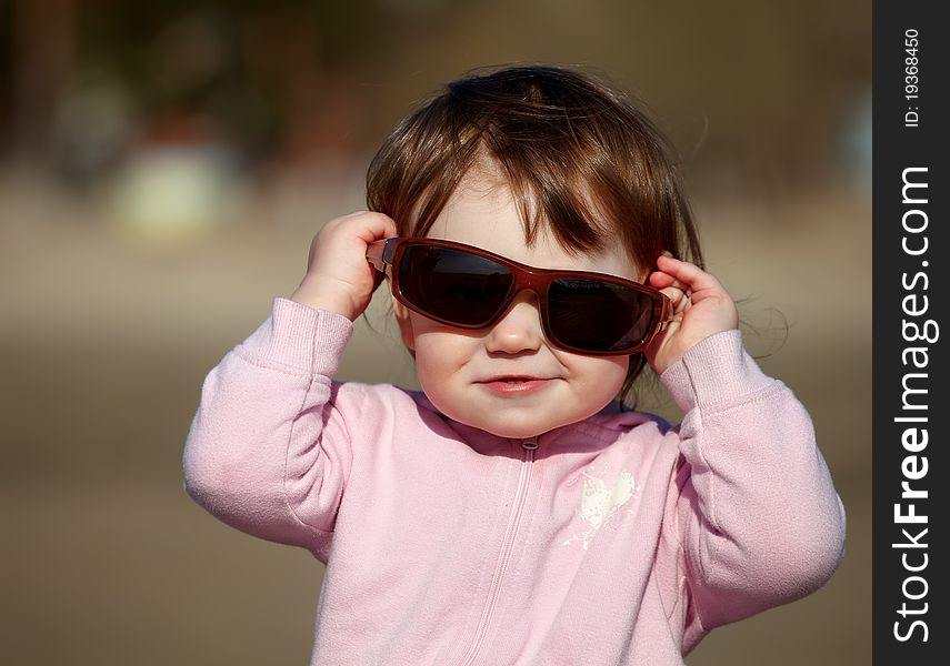 The portrait of a little girl in sunglasses. The portrait of a little girl in sunglasses