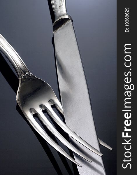 A fork and a knife on a neutral background. A fork and a knife on a neutral background
