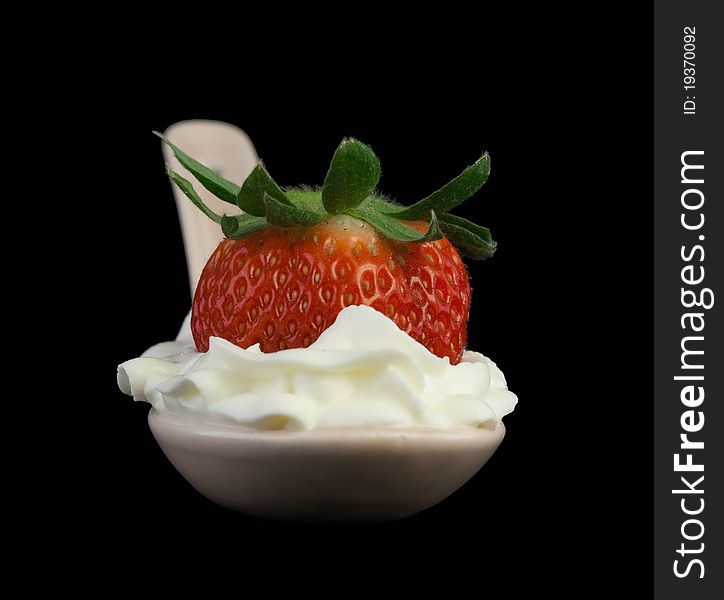 Strawberry with whipped cream. Isolated on a black background.
