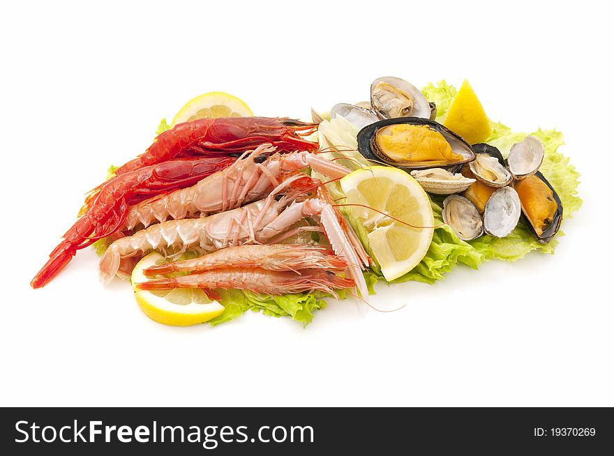 Mixed seafood over a bed of lettuce and lemon isolated on white background