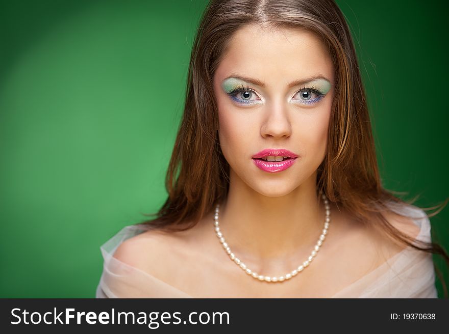 Portrait of a pretty girl on the green background