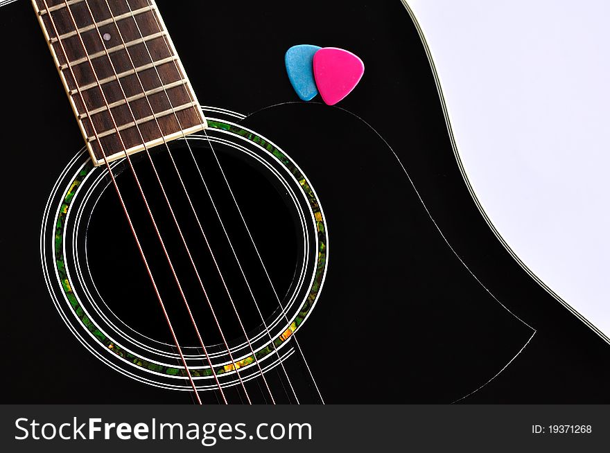 A detail of a black acoustic guitar. A detail of a black acoustic guitar