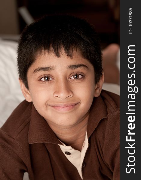 Handsome Indian kid lying happily on the bed. Handsome Indian kid lying happily on the bed