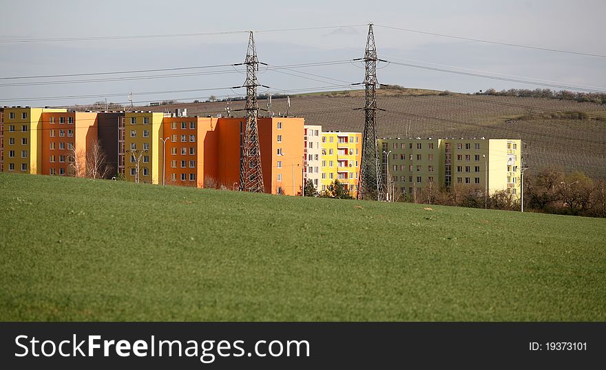 Coloured prefab houses with many windows hidden by the green field. Coloured prefab houses with many windows hidden by the green field