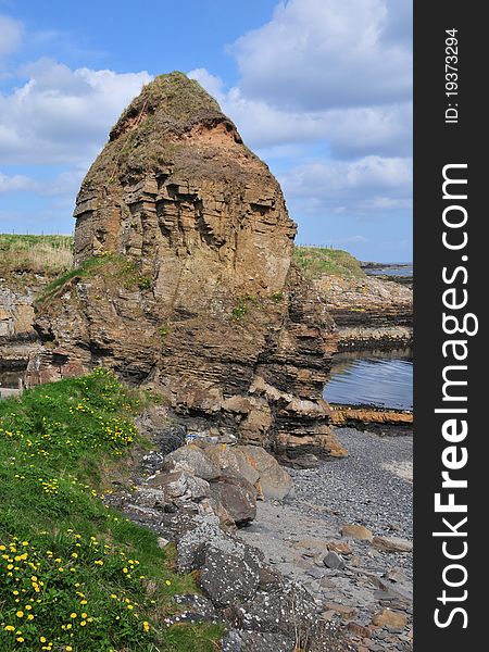 Staxigoe Rock, Staxigoe, Caithness, Scotland, UK. The rock stands by the Harbour. Staxigoe is a former fishing village, located 2 miles east of Wick on the north-eastern coast of the former county of Caithness, Scottish Highlands and is in the Scottish council area of Highland. Its name derives from Norse, &#x22;the inlet of the stack&#x22;. It was once the largest herring salting station in Europe, but its fishing industry went into decline with the construction of a larger port in central Wick. The name comes from two Norse words - &#x22;GJA&#x22; or &#x22;GOE&#x22; meaning an inlet, and &#x22;STAKKR&#x22; meaning a rock or stack, hence &#x22;Staxigoe&#x22;, the inlet of the stack. At the end of the 18th and the beginning of the 19th century, a few unscrupulous landlords began evicting tenants from land which had been theirs since the times of the clan system. Sheep had arrived in the Highlands, and the &#x22;Highland Clearances&#x22; began. Men were sent to war out of loyalty to their chief, and those who returned found their homes and crofts burned and their families scattered to the four corners of the earth. Those who were left - women, children, and the old people - had to walk the 100 miles or more from the hills and straths of Sutherland to the bleak and barren coasts to try to find settlements and a means of living. The growth in the population of Staxigoe, Wick and many hamlets and villages along the coast resulted in the birth of herring fishing. Inexperienced men