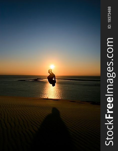 Silhouette of man jumping in sunset