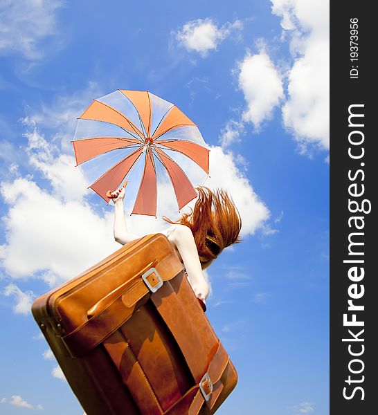 Redhead enchantress with suitcase jump in the sky.
