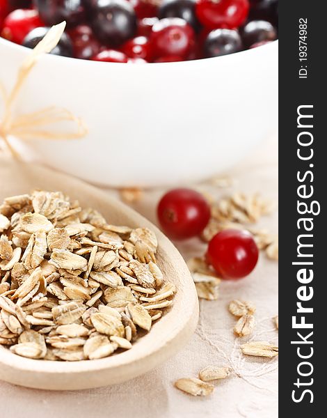 Healthy oat flakes on a wooden spoon and berries. Healthy oat flakes on a wooden spoon and berries.