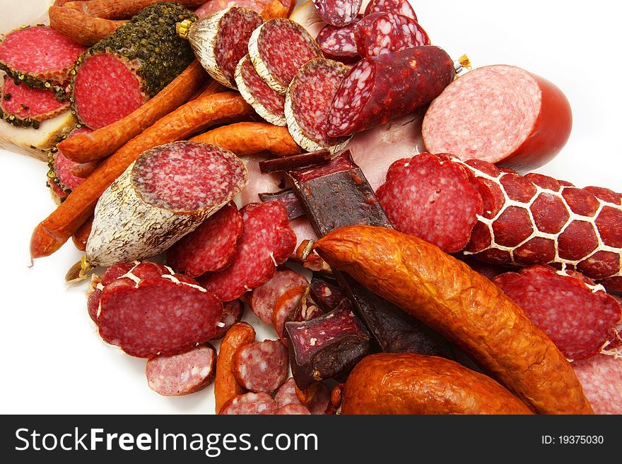 Various sausages are cut and spread out on a white background. Various sausages are cut and spread out on a white background
