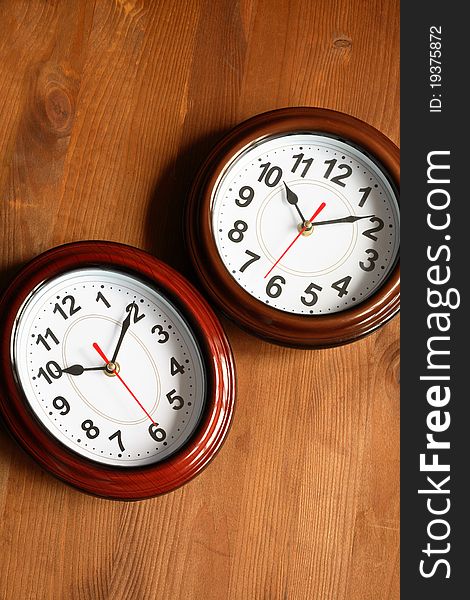 Pair of nice modern clocks on wooden surface. Pair of nice modern clocks on wooden surface