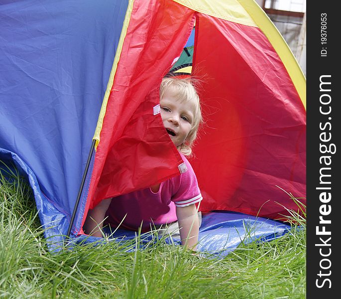 Child Sitting Inside Colorful Tent