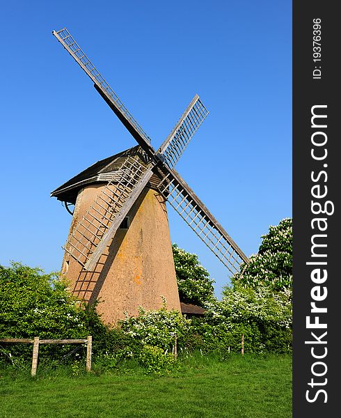 An old 17th century windmill against a clear blue sky. An old 17th century windmill against a clear blue sky