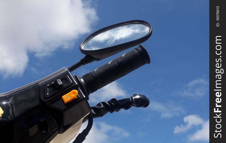 Right side of a typical motorcycle with side mirror, light switch and horn button. Right side of a typical motorcycle with side mirror, light switch and horn button