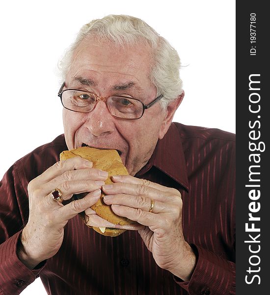 A senior man enjoying a great submarine sandwich. A senior man enjoying a great submarine sandwich.