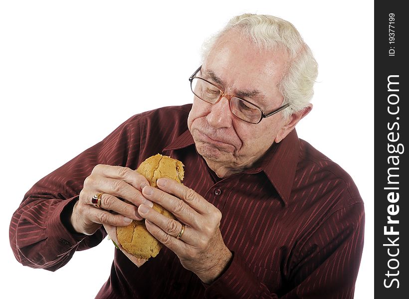 A senior man enjoying a big bite off his submarine sandwich. A senior man enjoying a big bite off his submarine sandwich.
