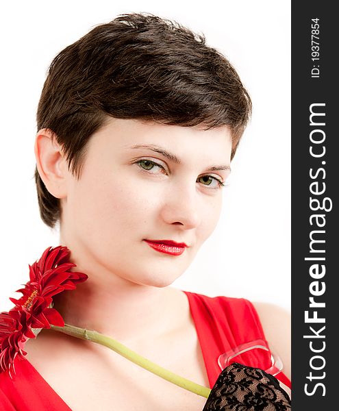 Brunette beauty portrait in red with red gerbera on white background. Brunette beauty portrait in red with red gerbera on white background