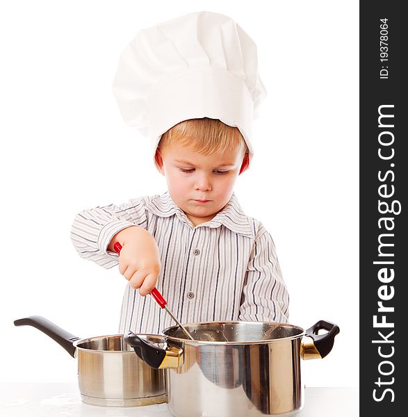 A funny cute boy is portraying a cook. isolated on a white background. A funny cute boy is portraying a cook. isolated on a white background